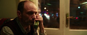 Movie still from “War Dogs” (2016), directed by Todd Phillips – A man talking on a phone while sitting in a bus; Close Up shot, Low angle
