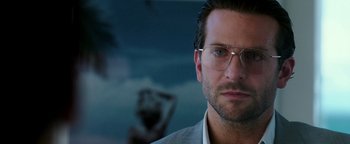Movie still from “War Dogs” (2016), directed by Todd Phillips – A person wearing glasses and a suit; Close Up shot, Over the shoulder angle