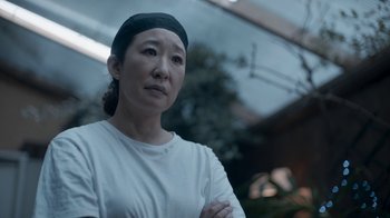 Movie still from “Killing Eve” (2018), created by Phoebe Waller-Bridge – A woman in a white shirt and a black headband; Close Up shot, Over the shoulder angle