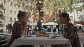 Movie still from “Killing Eve” (2018), created by Phoebe Waller-Bridge – Two women sitting at a table in front of plates of food; Medium shot, Over the shoulder angle