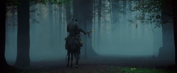 Movie still from “War for the Planet of the Apes” (2017), directed by Matt Reeves – A man riding a horse through the woods; Wide shot, Low angle
