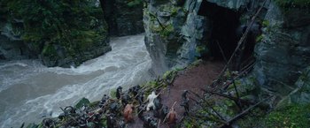 Movie still from “War for the Planet of the Apes” (2017), directed by Matt Reeves – A group of people standing on top of a cliff next to a river; Extreme Wide shot, High angle