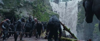 Movie still from “War for the Planet of the Apes” (2017), directed by Matt Reeves – A group of people standing next to each other near a waterfall; Wide shot, Low angle