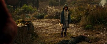 Movie still from “War for the Planet of the Apes” (2017), directed by Matt Reeves – A young girl in a hooded jacket and boots in the woods; Wide shot, High angle
