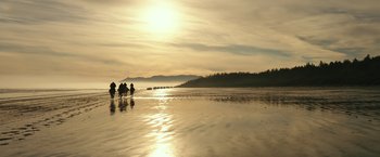 Movie still from “War for the Planet of the Apes” (2017), directed by Matt Reeves – A group of people riding horses on top of a sandy beach; Extreme Wide shot, Low angle
