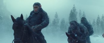 Movie still from “War for the Planet of the Apes” (2017), directed by Matt Reeves – A man riding on the back of a horse next to a monkey; Medium shot, Low angle