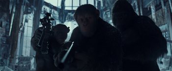 Movie still from “War for the Planet of the Apes” (2017), directed by Matt Reeves – A man holding a gun while standing next to another man; Medium shot, Low angle
