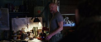 Movie still from “War for the Planet of the Apes” (2017), directed by Matt Reeves – A man standing at a table in the dark; Medium shot, Low angle