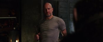 Movie still from “War for the Planet of the Apes” (2017), directed by Matt Reeves – A bald man holding a pair of knifes in his hand; Medium shot, Low angle