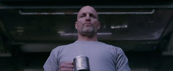 Movie still from “War for the Planet of the Apes” (2017), directed by Matt Reeves – A bald man holding a tin can in his hand; Close Up shot, Low angle