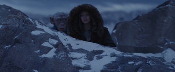 Movie still from “War for the Planet of the Apes” (2017), directed by Matt Reeves – A man and a woman are standing next to each other in the snow; Medium shot, Over the shoulder angle