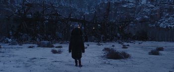 Movie still from “War for the Planet of the Apes” (2017), directed by Matt Reeves – A person standing in the middle of a snowy field at night; Wide shot, High angle