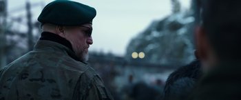 Movie still from “War for the Planet of the Apes” (2017), directed by Matt Reeves – A person wearing a hat and glasses; Close Up shot, Over the shoulder angle