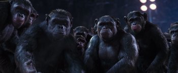 Movie still from “War for the Planet of the Apes” (2017), directed by Matt Reeves – A group of monkeys standing next to each other in the dark; Medium shot, Low angle