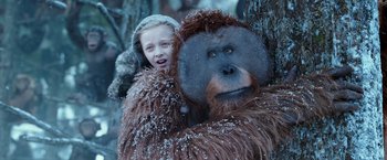 Movie still from “War for the Planet of the Apes” (2017), directed by Matt Reeves – A young girl is hugging an animal in a snowy forest; Close Up shot, Low angle