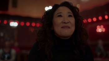 Movie still from “Killing Eve” (2018), created by Phoebe Waller-Bridge – A person with curly hair looking up; Close Up shot, Over the shoulder angle