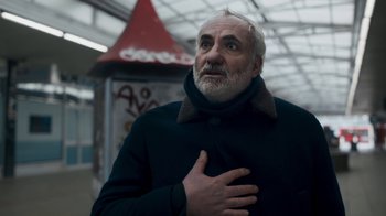 Movie still from “Killing Eve” (2018), created by Phoebe Waller-Bridge – An older man with white hair and a goatee; Medium shot, Low angle