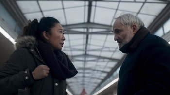 Movie still from “Killing Eve” (2018), created by Phoebe Waller-Bridge – A man and a woman standing next to each other on a train platform; Close Up shot, Over the shoulder angle