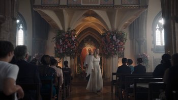 Movie still from “Killing Eve” (2018), created by Phoebe Waller-Bridge – Two people are walking down the aisle of a church; Wide shot, Low angle