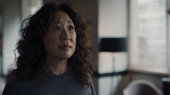 Movie still from “Killing Eve” (2018), created by Phoebe Waller-Bridge – An asian woman with long curly brown hair looking up; Close Up shot, Over the shoulder angle