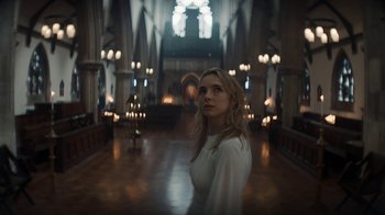 Movie still from “Killing Eve” (2018), created by Phoebe Waller-Bridge – A woman standing in the middle of an aisle in a church; Medium shot, Low angle