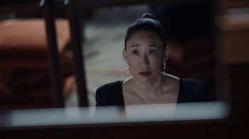 Movie still from “Killing Eve” (2018), created by Phoebe Waller-Bridge – A woman looking at her reflection in a mirror; Close Up shot, Over the shoulder angle