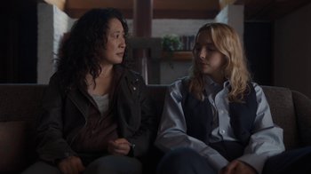 Movie still from “Killing Eve” (2018), created by Phoebe Waller-Bridge – Two women sitting on a couch talking to each other; Medium shot, Over the shoulder angle