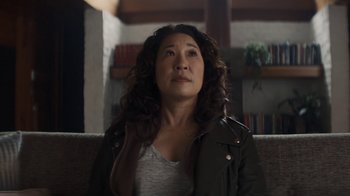 Movie still from “Killing Eve” (2018), created by Phoebe Waller-Bridge – A woman sitting on top of a couch in a living room; Close Up shot, Over the shoulder angle