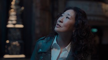 Movie still from “Killing Eve” (2018), created by Phoebe Waller-Bridge – A person wearing a jacket looking up; Close Up shot, Over the shoulder angle