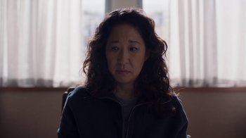 Movie still from “Killing Eve” (2018), created by Phoebe Waller-Bridge – A person sitting in front of a window; Close Up shot, High angle