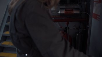 Movie still from “Killing Eve” (2018), created by Phoebe Waller-Bridge – A person is working on a machine in a dark room; Close Up shot, High angle