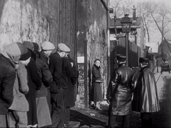 Movie still from “L'Atalante” (1934), directed by Jean Vigo – A black and white photo of a group of people standing outside; Wide shot, High angle