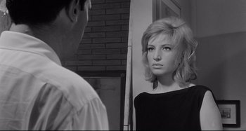 Movie still from “L'Eclisse” (1962), directed by Michelangelo Antonioni – A woman looking at a man in front of a mirror; Close Up shot, Over the shoulder angle