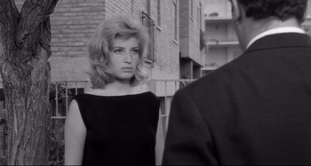 Movie still from “L'Eclisse” (1962), directed by Michelangelo Antonioni – A black and white photo of a woman looking at a man; Close Up shot, Over the shoulder angle