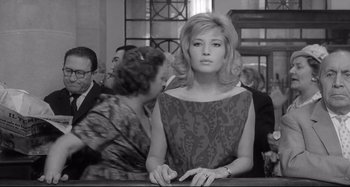 Movie still from “L'Eclisse” (1962), directed by Michelangelo Antonioni – An old photo of a woman sitting at a table; Medium shot, Low angle