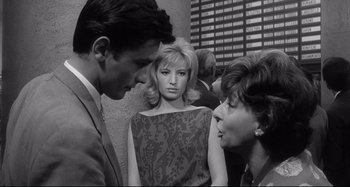 Movie still from “L'Eclisse” (1962), directed by Michelangelo Antonioni – A man and a woman talking to another woman in front of another woman; Medium shot, Over the shoulder angle