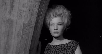 Movie still from “L'Eclisse” (1962), directed by Michelangelo Antonioni – A black and white photo of a woman in a dress; Close Up shot, Low angle