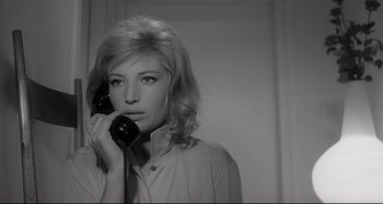 Movie still from “L'Eclisse” (1962), directed by Michelangelo Antonioni – A black and white photo of a woman holding a phone to her ear; Close Up shot, Low angle