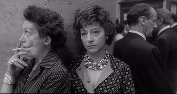 Movie still from “L'Eclisse” (1962), directed by Michelangelo Antonioni – An older woman wearing a dress and a pearl necklace; Close Up shot, Low angle