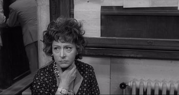 Movie still from “L'Eclisse” (1962), directed by Michelangelo Antonioni – An older woman is sitting in front of a window; Close Up shot, High angle