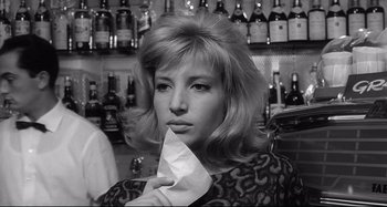 Movie still from “L'Eclisse” (1962), directed by Michelangelo Antonioni – A black and white photo of a woman holding a piece of paper; Close Up shot, Low angle