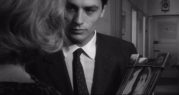 Movie still from “L'Eclisse” (1962), directed by Michelangelo Antonioni – A man in a black suit and a woman in a black suit; Close Up shot, Over the shoulder angle