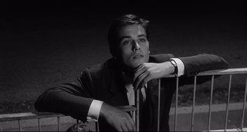 Movie still from “L'Eclisse” (1962), directed by Michelangelo Antonioni – Black and white photograph of a man leaning on a railing; Close Up shot, Low angle