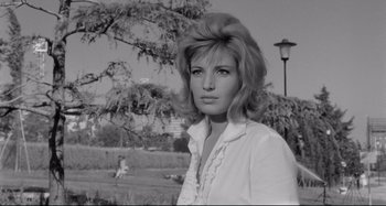 Movie still from “L'Eclisse” (1962), directed by Michelangelo Antonioni – A black - and - white photo of a woman in a white shirt; Close Up shot, Low angle