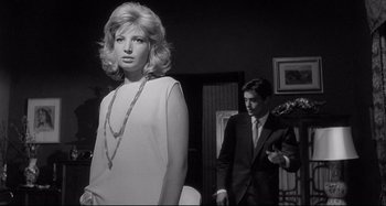 Movie still from “L'Eclisse” (1962), directed by Michelangelo Antonioni – A man and a woman standing next to each other in a room; Medium shot, Low angle