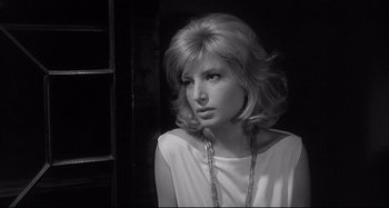 Movie still from “L'Eclisse” (1962), directed by Michelangelo Antonioni – A black and white photo of a woman in a white shirt; Close Up shot, Over the shoulder angle