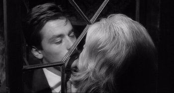 Movie still from “L'Eclisse” (1962), directed by Michelangelo Antonioni – A black and white photo of a man and a woman kissing; Close Up shot, Over the shoulder angle