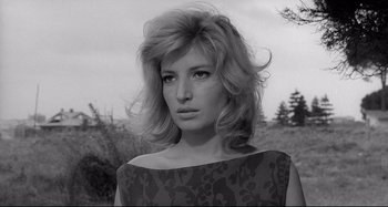 Movie still from “L'Eclisse” (1962), directed by Michelangelo Antonioni – A black and white photo of a woman in a field; Close Up shot, Low angle