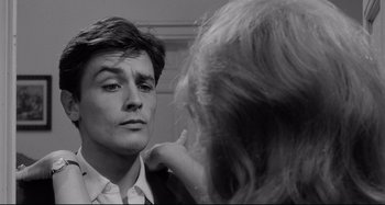 Movie still from “L'Eclisse” (1962), directed by Michelangelo Antonioni – A young man looking at a woman in a mirror; Close Up shot, Over the shoulder angle
