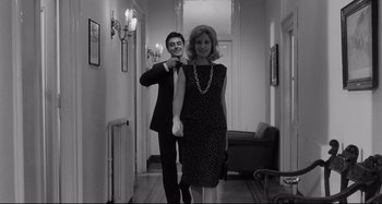 Movie still from “L'Eclisse” (1962), directed by Michelangelo Antonioni – A man and a woman are standing in a hallway; Medium shot, Low angle